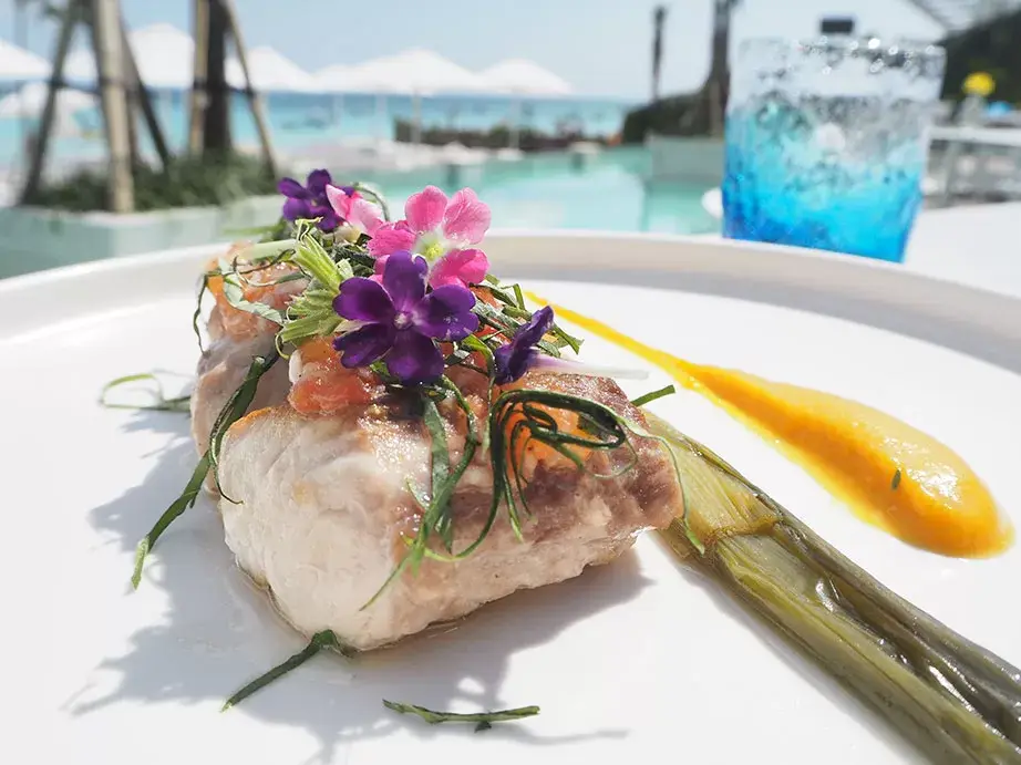 Steamed fish with edible flowers served beside the pool at Azure Beach Club