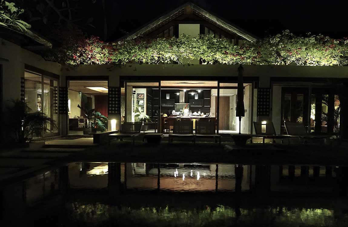 Villa living area and pool after dark